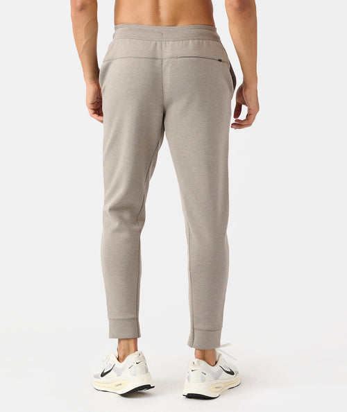 Taupe heather joggers with elastic waistband and cuffed ankles, shown from back view on male model.