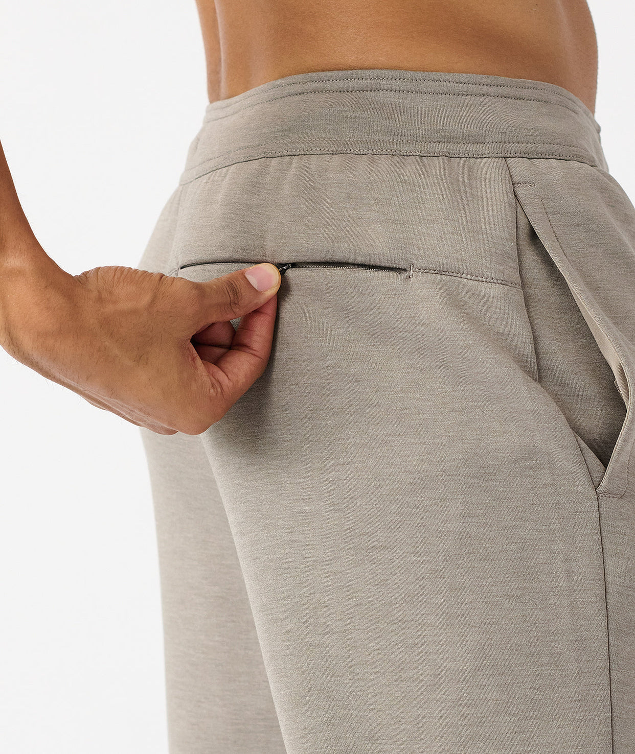 Taupe heather joggers with elastic waistband and side pocket, shown from waist to thigh on model.