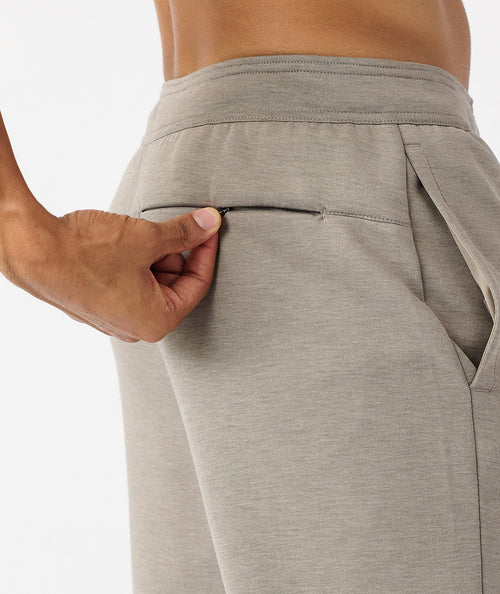 Taupe heather joggers with elastic waistband and side pocket, shown from waist to thigh on model.