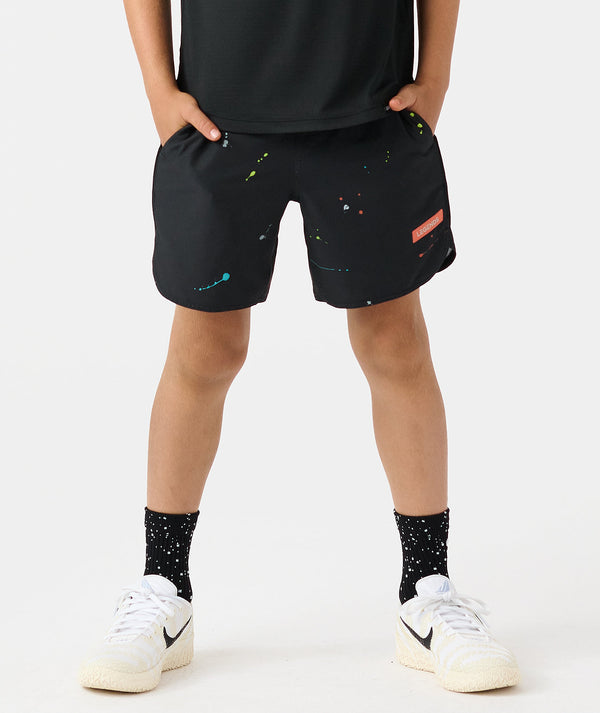 Black shorts with colorful scattered dot and line graphics, elastic waistband with drawstring, worn with black socks and whit