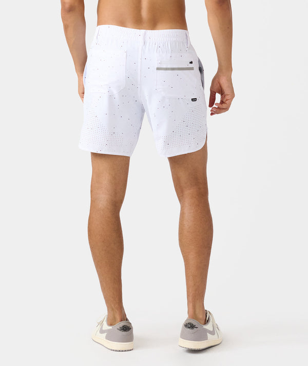 White golf shorts with black splatter pattern, rear pockets, and perforated lower legs on model.