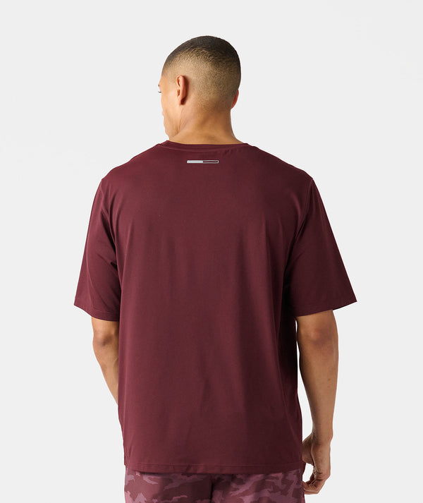 Man wearing a burgundy short-sleeve crew neck t-shirt, shown from back view.