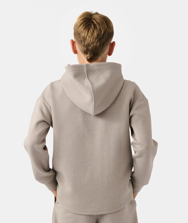 Child wearing taupe quarter-zip hoodie with hood down, shown from back view.
