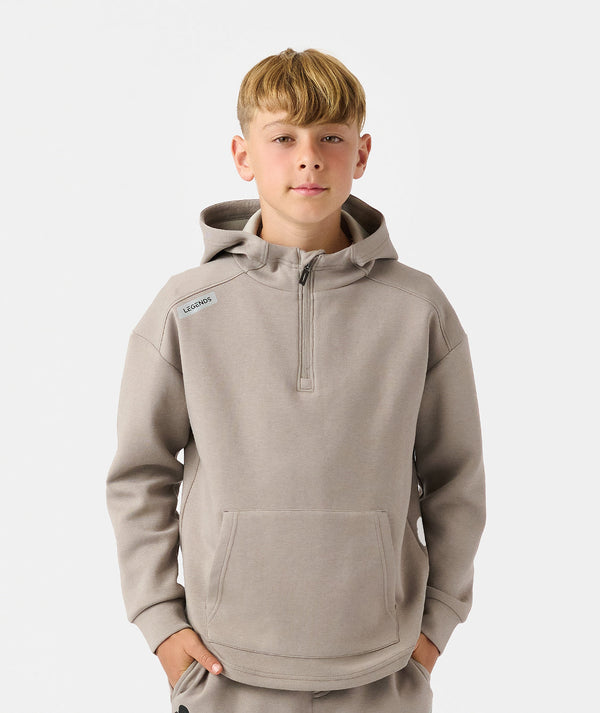 Child wearing taupe quarter-zip hoodie with front kangaroo pocket and brand logo on chest.