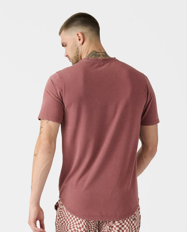 Washed ember tee with curved hem, shown from back on model wearing checkered pants.