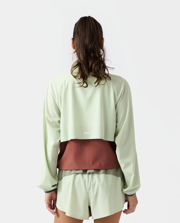 Light sage cropped jacket with burgundy color-block panel at waist, shown from back view.