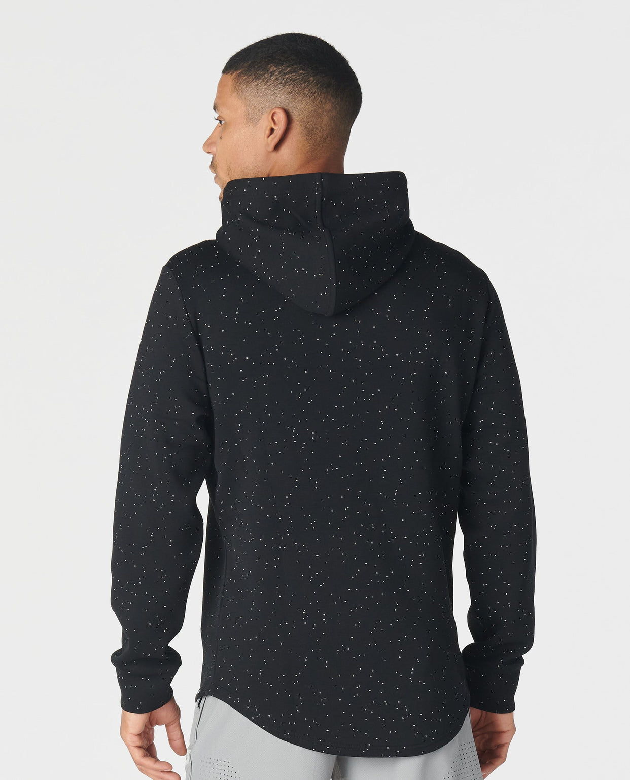 Black hoodie with white speckled splatter pattern throughout, shown from back view on model.