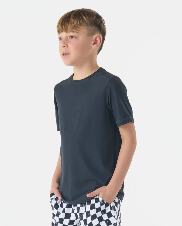 Child wearing black crew neck t-shirt with short sleeves, paired with black and white checkered pants.
